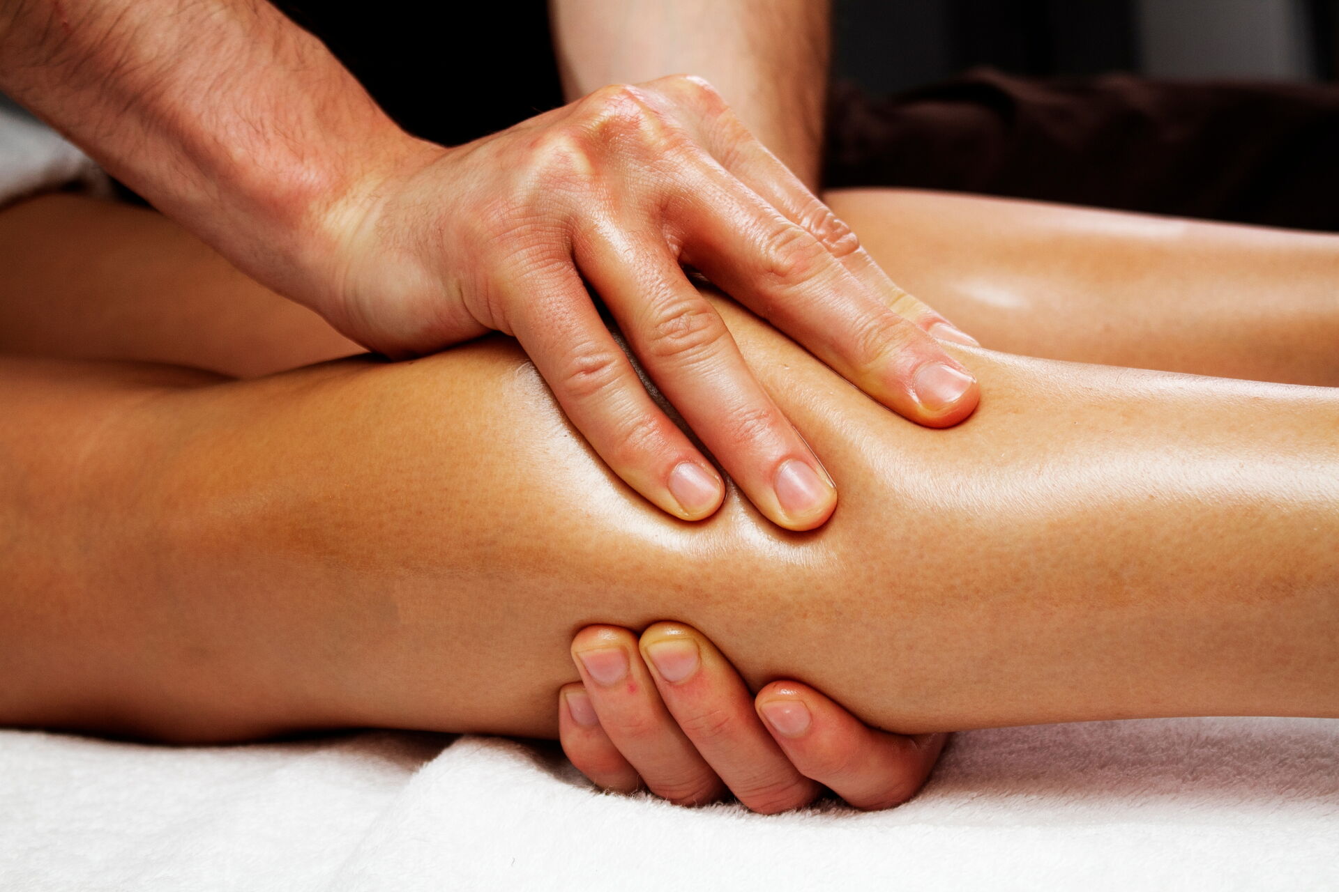 Manuelle Lymphdrainage dargestellt durch zwei Hände bei der Massage eines Wadenbereiches